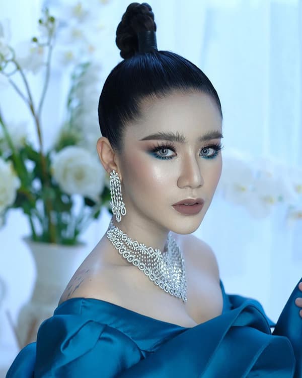 ผู้หญิงใส่ชุดราตรีสีน้ำเงิน เกล้าผมสูง